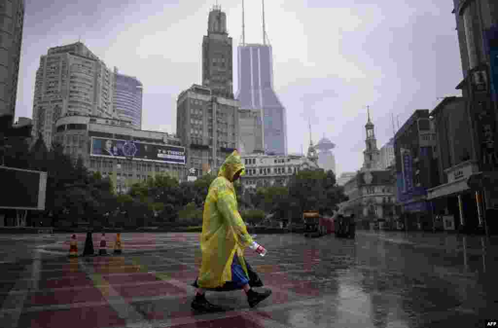 2018年8月25日，上海一条步行街，降雨时，街道清洁工带着一个空水瓶。