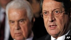 FILE - Cyprus' president Nicos Anastasiades (r) and Turkish Cypriot leader Dervis Eroglu, talk to the media after their meeting in the divided capital Nicosia.