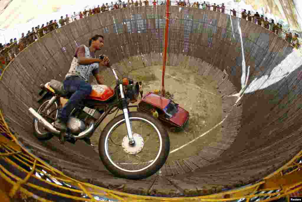 네팔 바크타푸르에서 열린 박람회에서 한 스턴트맨이 '죽음의 벽'이라는 구조물 안에서 오토바이 묘기를 선보이고 있다.
