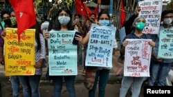 Students wearing protective face masks hold placards as they participate in a protest march demanding postponement of admission tests to medical and engineering schools amidst the spread of COVID-19, in Kolkata, India, Aug. 29, 2020.