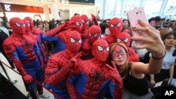 Event workers wearing Spider-Man costumes pose for a selfie for a fan during a promotional event for the film "Spider-Man: Homecoming" in Seoul, South Korea, Sunday, July 2, 2017. 