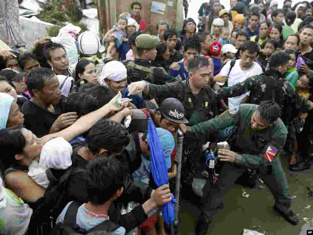 필리핀 타클로반 시의&nbsp; 태풍 피해 생존자들이 12일 구호 비행기에 먼저 오르기 위해 서로 밀치고 있다.