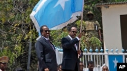 Rais wa Somalia Mohamed Abdullahi Farmajo, kulia,akipeperusha bendera ya Somalia katika ikulu Mogadishu. Alhamisi, Feb. 16, 2017. 