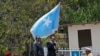 Somalia's President Mohamed Abdullahi Farmajo, center-right, holds a Somali flag during a handover ceremony at the presidential palace with former president Hassan Sheikh Mohamud, center-left, in Mogadishu, Somalia Thursday, Feb. 16, 2017. 