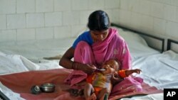 A mother feeds her malnourished child at the Nutritional Rehabilitation Centre in Sheopur district in the central Indian state of Madhya Pradesh, April 6, 2010