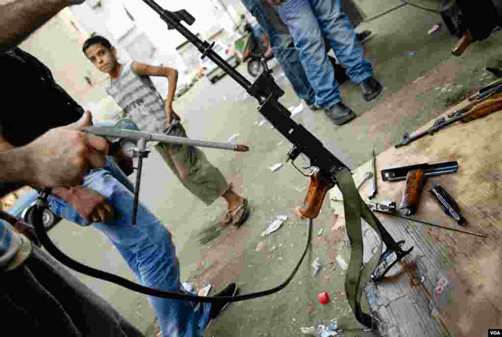 Fighters from the Bab Tabbaneh neighborhood of Tripoli, Lebanon, gather to clean their weapons, August 25, 2012. (VOA/Jeff Neumann)