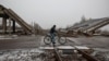 FILE - A local resident rides a bicycle near a destroyed bridge, amid Russia's attack on Ukraine, in the town of Pokrovsk, near a front line in Donetsk region, Ukraine, Dec. 19, 2024.