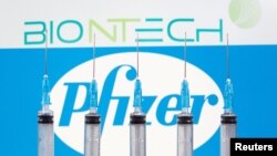 FILE - Syringes are seen in front of displayed Biontech and Pfizer logos in this illustration taken November 10, 2020. (REUTERS/Dado Ruvic/Illustration/File Photo)