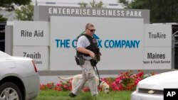 ATF police officer with a sniffing dog walks out the industrial complex in Harford County, Maryland, Sept. 20, 2018. 