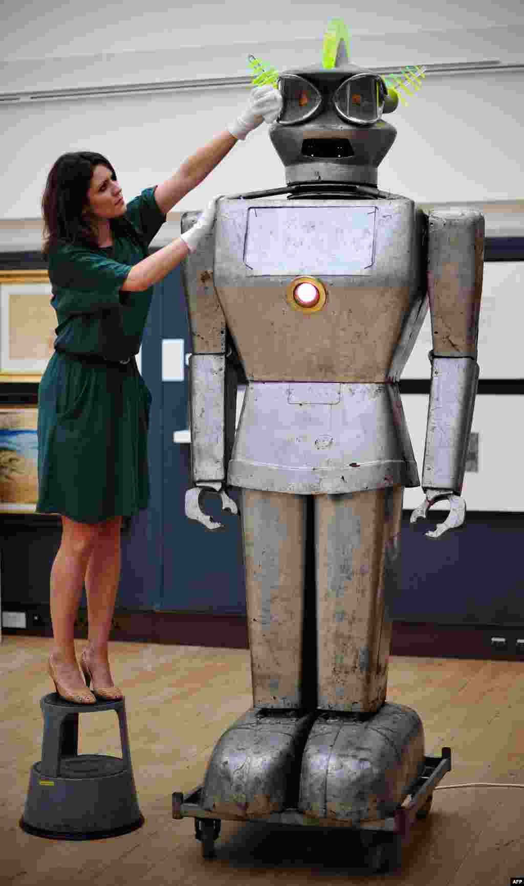 A member of staff poses with a robot called &#39;Cygan&#39; at Christies auction house in central London, England. It was one of the most sophisticated robots of its time with an ability to accept spoken commands and respond to light rays.