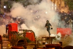 FILE - Anti-government protesters clash with the riot police, during a protest near the parliament square, in downtown Beirut, Lebanon, Dec. 15, 2019.