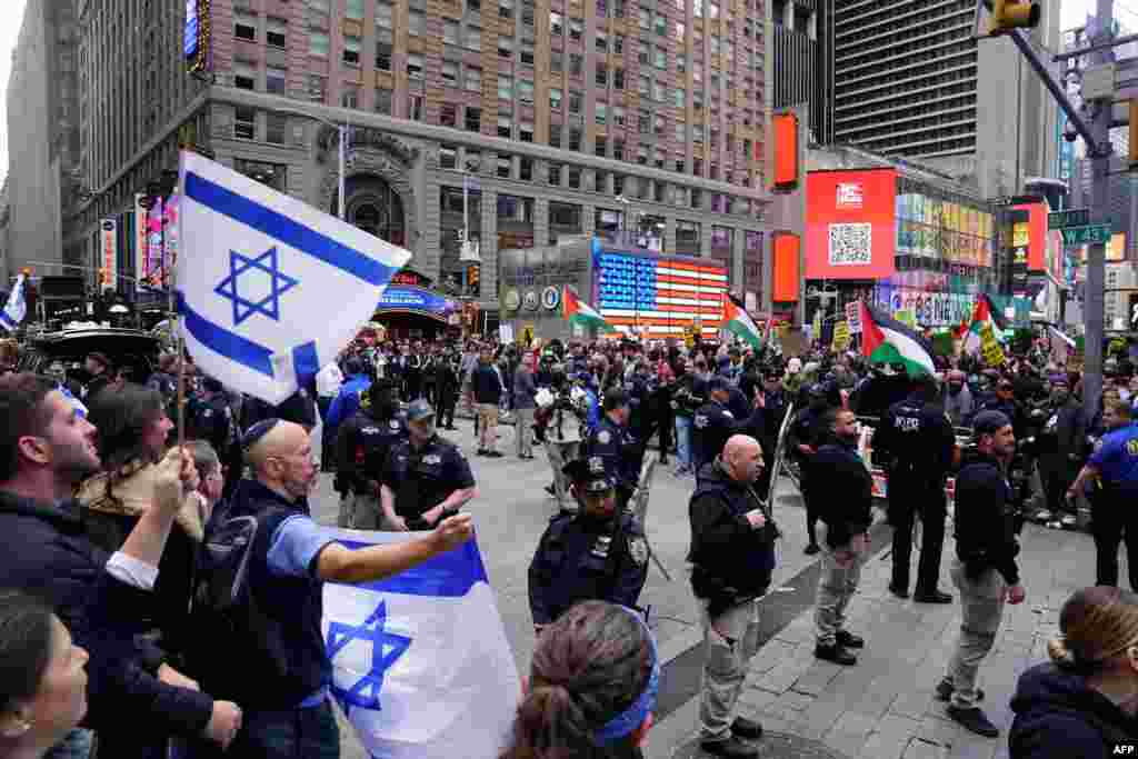 Polisi wa mjini New York wakiwatenganisha waandamanaji wanaoiunga mkono Israel (kushoto) kuwakaribia waandamanaji wanayoiunga mkono Palestina (kulia), kwenye uwanja wa Times Square Oktoba 8, 2023 baada ya wanamgambo wa Hamas kuishambulia Israel.&nbsp;