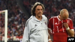 Le médecin de l'équipe allemande de football et du Bayern Munich, Hans-Wilhelm Müller-Wohlfahrt, à gauche, aide le milieu de terrain bavarois, Arjen Robben, blessé lors du match aller du FC Bayern Munich contre le Real Madrid CF à Munich, dans le sud de l
