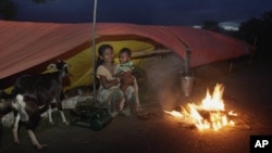 Banjir pada Juli 2012 membuat seorang perempuan dan bayinya mengungsi ke tempat penampungan sementara di Jhargaon, negara bagian Assam, India. (Foto: Dok)