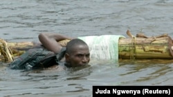 Un homme traverse à la nage la rivière Monserado à Monrovia, au Liberia, le 14 août 2003. 