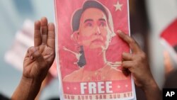 Pendukung Aung San Suu Kyi membawa gambar Pemimpin Myanmar tersebut dengan mengacungkan tiga jari, saat menggelar aksi protes di depan Kedutaan Myanmar di Bangkok, Thailand, 8 Februari 2021. (Foto: dok).