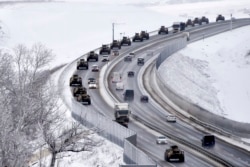 A convoy of Russian armored vehicles moves along a highway in Crimea, Jan. 18, 2022. Russia has concentrated an estimated 100,000 troops with tanks and other heavy weapons near Ukraine .