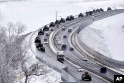 A convoy of Russian armored vehicles moves along a highway in Crimea, Jan. 18, 2022. Russia has concentrated an estimated 100,000 troops with tanks and other heavy weapons near Ukraine .