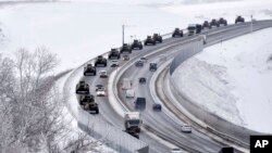 A convoy of Russian armored vehicles moves along a highway in Crimea, Jan. 18, 2022. Russia has concentrated an estimated 100,000 troops with tanks and other heavy weapons near Ukraine .