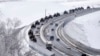 A convoy of Russian armored vehicles moves along a highway in Crimea, Jan. 18, 2022. Russia has concentrated an estimated 100,000 troops with tanks and other heavy weapons near Ukraine .