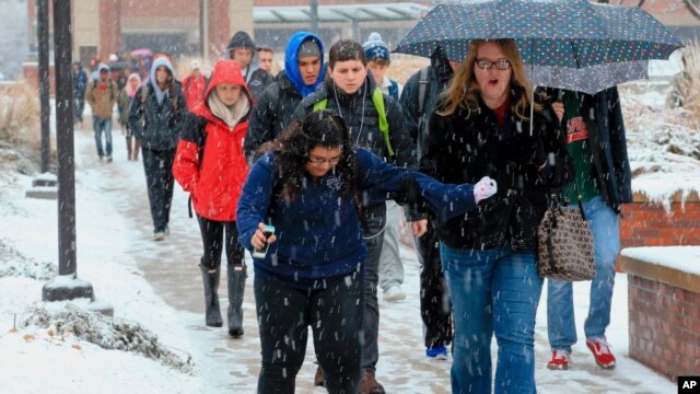 Una estudiante en el campus de la Universidad de Nebraska, en Omaha, se resbala en un camino el lunes, 30 de noviembre de 2015.