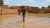 Un enfant patauge dans l'eau dans une rue inondée du quartier de Kirkissoye à Niamey, le 3 septembre 2019. 