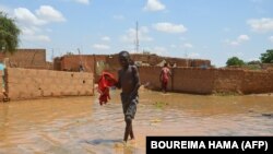 Un enfant patauge dans l'eau dans une rue inondée du quartier de Kirkissoye à Niamey, au Niger, le 3 septembre 2019. (Photo BOUREIMA HAMA / AFP)