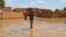 Un enfant patauge dans l'eau dans une rue inondée du quartier de Kirkissoye à Niamey, le 3 septembre 2019. 