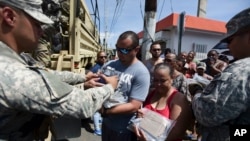 National Guardsmen arrive at Barrio Obrero in Santurce to distribute water and food among those affected by the passage of Hurricane Maria, in San Juan, Puerto Rico, Sept. 24, 2017. 