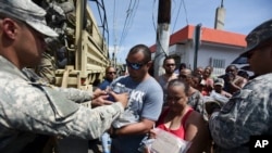National Guardsmen arrive at Barrio Obrero in Santurce to distribute water and food among those affected by the passage of Hurricane Maria, in San Juan, Puerto Rico, Sept. 24, 2017.