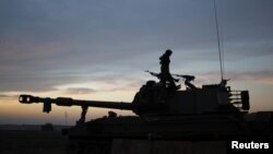 An Israeli soldier stands atop a mobile artillery unit positioned outside the northern Gaza Strip, November 21, 2012.