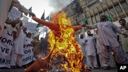 Protesters, who are demonstrating against a NATO cross-border attack, burn an effigy representing the U.S. in Karachi, November 27, 2011.