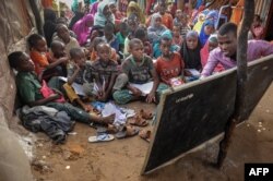 FILE - Displaced Somali children and teenagers are taught letters and numbers at a makeshift school at the Badbado IDP camp in Mogadishu, Somalia, June 25, 2018.