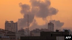 O fumo sobe por cima dos edifícios durante um ataque aéreo israelita, na cidade de Gaza, a 9 de outubro de 2023.
