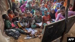 Yahye Mohamed donne une leçon aux enfants déplacés dans une école de fortune au camp de Badbado à Mogadiscio, en Somalie, le 25 juin 2018.