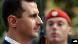 ARCHIVO - El presidente de Siria, Bashar Assad, pasa revista a la guardia presidencial durante una ceremonia de bienvenida en Atenas, el 15 de diciembre de 2003.