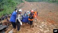 Rescuers carry the body of a landslide victim in Sirnaresmi, West Java, Indonesia, Jan. 1, 2019. 
