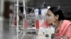 FILE - Bangladeshi garment worker Asma, who worked on the 4th floor of Rana Plaza garment factory that collapsed exactly a year ago, works at a factory meant to rehabilitate survivors of the accident, the worst in the history of the garment industry, in S