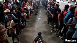 洪都拉斯移民隊伍在危地馬拉城排隊領取坐墊。 （2018年10月17日）