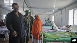 Jean Ping (L), chairman of the Commission of the African Union, visits wounded Transitional Federal Government soldiers at the African Union Mission in Somalia Level II hospital, at the operation's headquarters in Mogadishu, Somalia, August 20, 2011. (fil