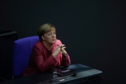 German Chancellor Angela Merkel listens to the debate about her policy as part of Germany's budget 2021 debate at the parliament Bundestag in Berlin, Germany, Sept. 30, 2020.