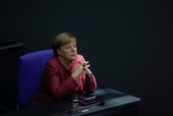 German Chancellor Angela Merkel listens to the debate about her policy as part of Germany's budget 2021 debate at the parliament Bundestag in Berlin, Germany, Sept. 30, 2020.