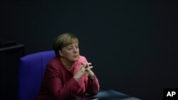 German Chancellor Angela Merkel listens to the debate about her policy as part of Germany's budget 2021 debate at the parliament Bundestag in Berlin, Germany, Sept. 30, 2020.