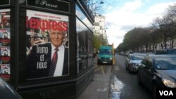 Un panneau publicitaire dans une rue parisienne reflète la réaction en France aux élections américaines, Paris, le 18 novembre 2016. (L. Bryant / VOA)