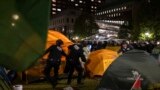 Сотрудники Департамента полиции Нью-Йорка проводят рейд в лагере протестующих в Колумбийском университете. 30 апреля 2024 года. (Marco Postigo Storel via AP)