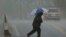 A man walks in a torrential downpour in Ellicott City, Maryland April 30, 2014.