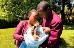 FILE - Daniel Muriri and Christine Wanjiru hold their newly born child after receiving facilitation from the free ambulance service provided during the coronavirus disease (COVID-19) night curfew in Nairobi, Kenya, June 30, 2020.