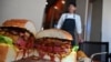 Patrick Shimada, chef dari restoran The Oak Door di Hotel Grand Hyatt Tokyo, berpose dengan burger buatannya seberat 3 kilogram, di Tokyo, 1 April 2019.