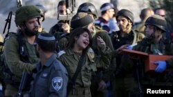 An Israeli soldier reacts at the scene where a Palestinian stabbed and killed an Israeli at a gas station before he was shot dead by soldiers Nov. 23, 2015, near the West Bank village of Khirbit Al-Misbah between Jerusalem and Tel Aviv.