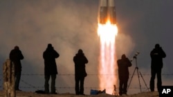 FILE - The Soyuz-FG rocket booster with the Soyuz TMA-19M spaceship carrying a crew to the International Space Station, ISS, blasts off at the Russian-leased Baikonur cosmodrome, Kazakhstan, Dec. 15, 2015. The flight of the next crew to the ISS will be delayed, the Russian space agency said Monday.